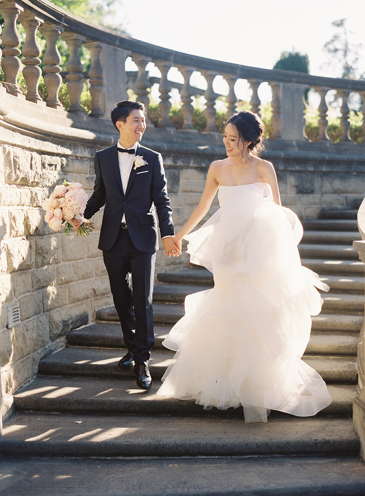 Bride and Groom walking down cement outside staircase