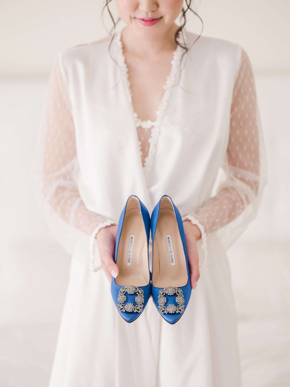 Bride holding out blue shoes