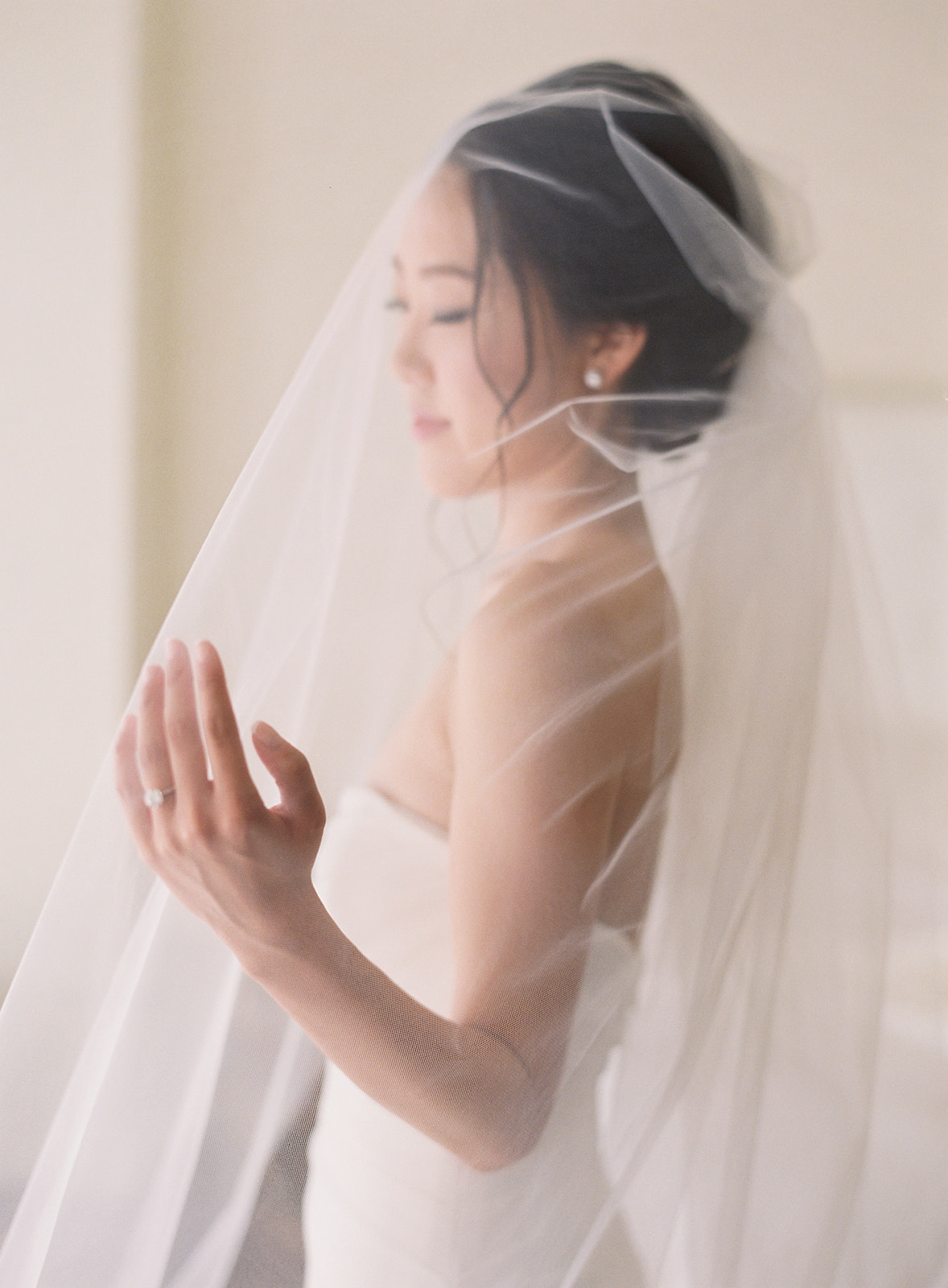 Bride under her long veil in a side profile shot