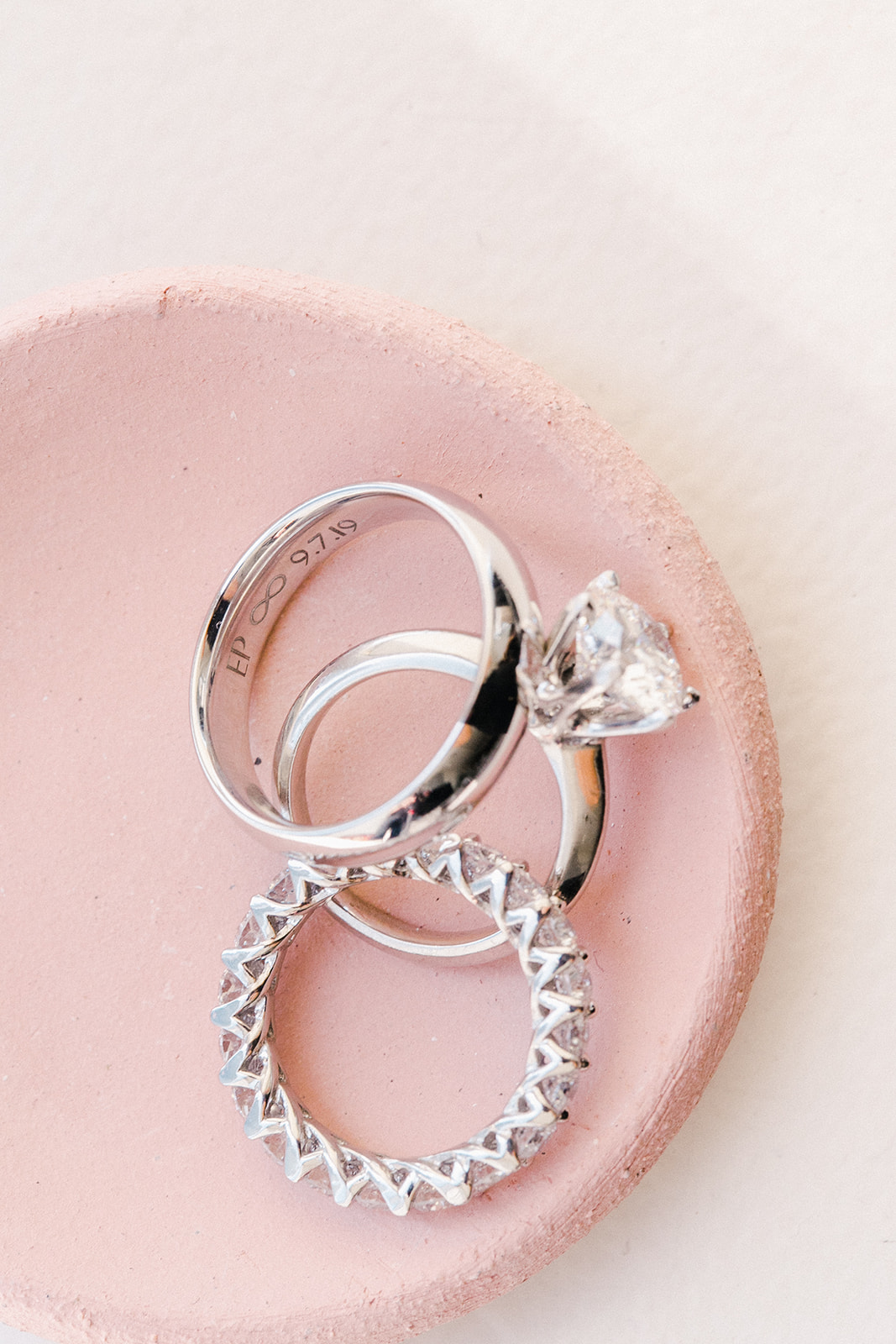 Close up of wedding rings/bands in pink dish