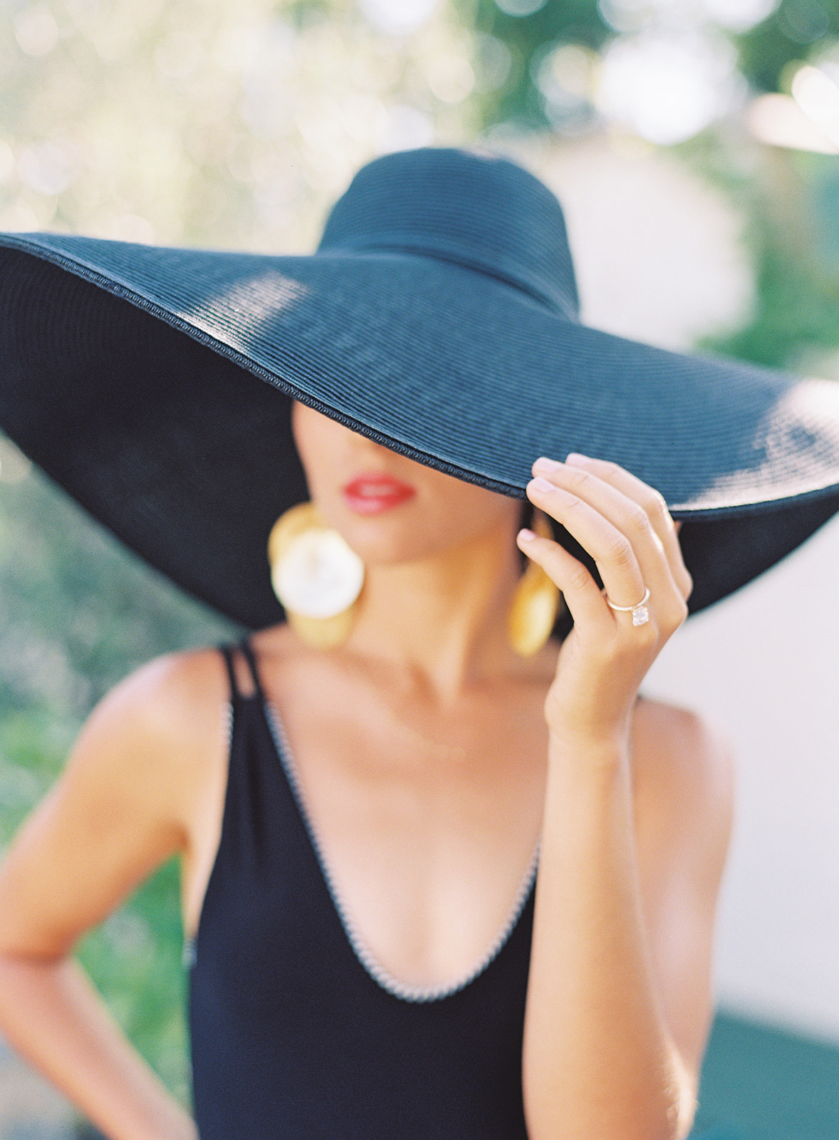 woman poolside in a big black hat